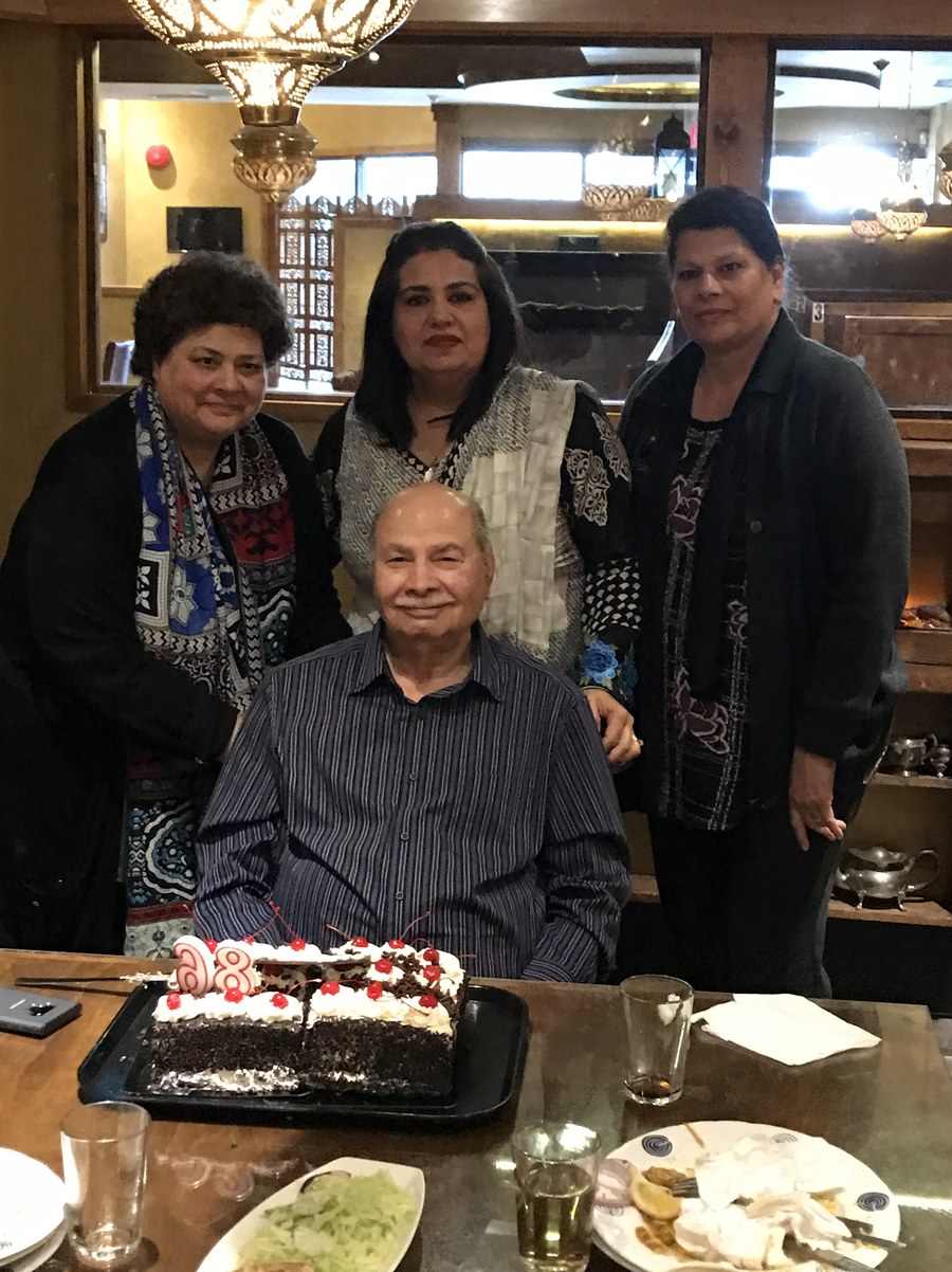 Aslam Hayat seated at his 85th birthday with cake and family, Vancouver