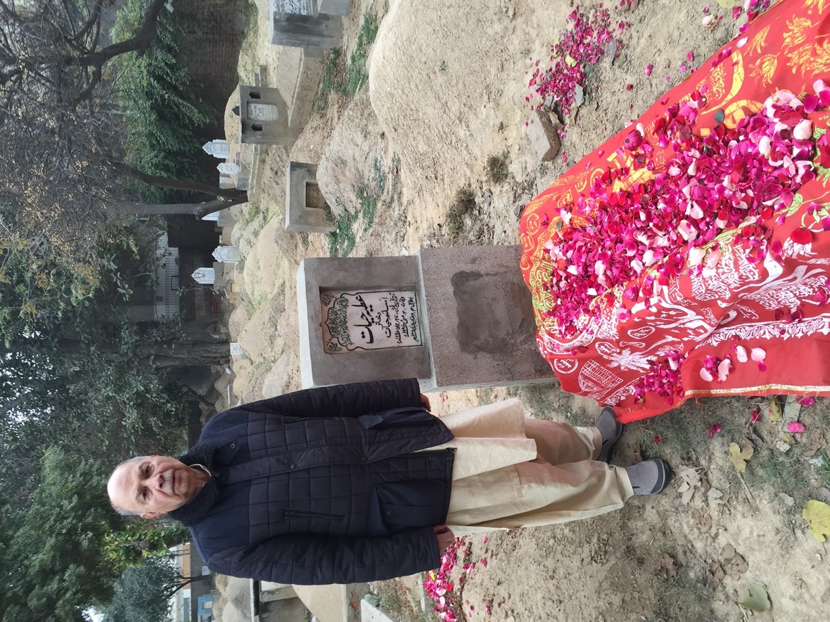 Aslam Hayat standing at the grave of his daughter Attiya Hayat, Lahore