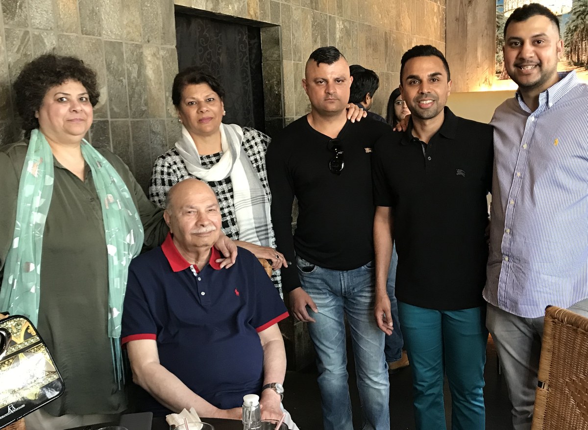 Aslam Hayat seated with family at a restaurant gathering