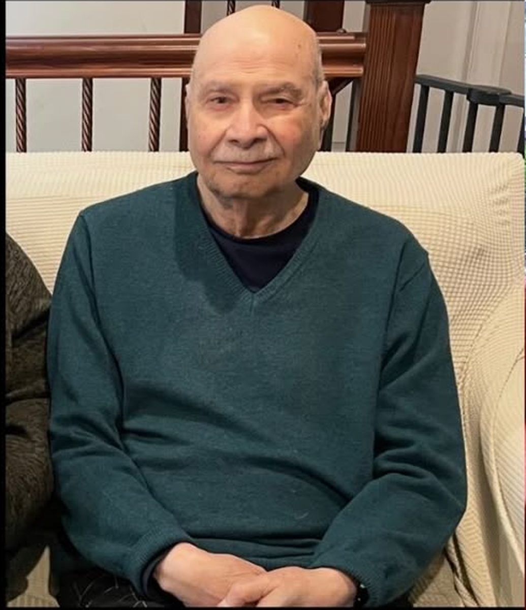 Aslam Hayat at home in Vancouver, wearing a green sweater