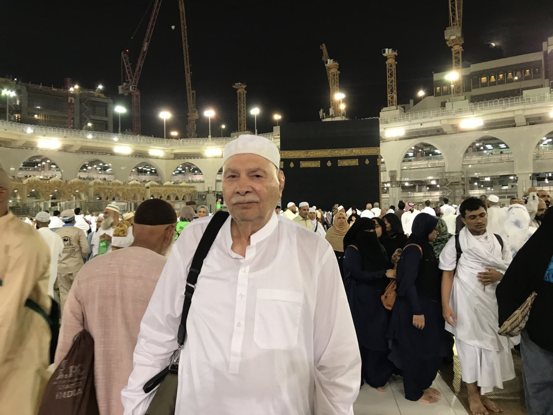 Aslam Hayat standing before the Holy Kaaba at the Masjid al-Haram, Mecca, at night