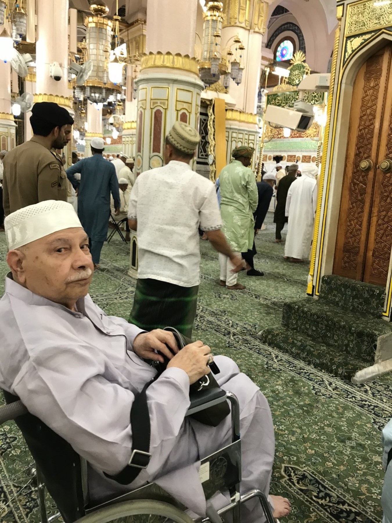 Aslam Hayat seated in a wheelchair inside the Masjid al-Nabawi, Madinah