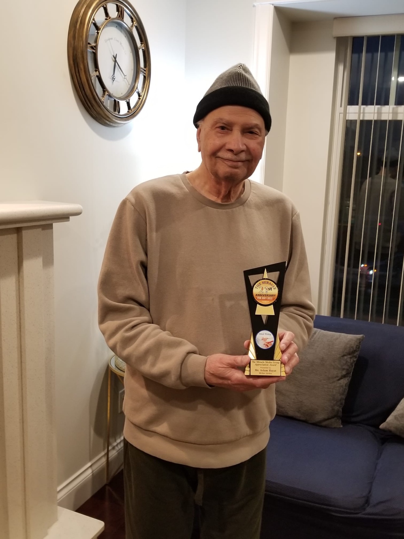 Aslam Hayat holding the Miracle Media Group award