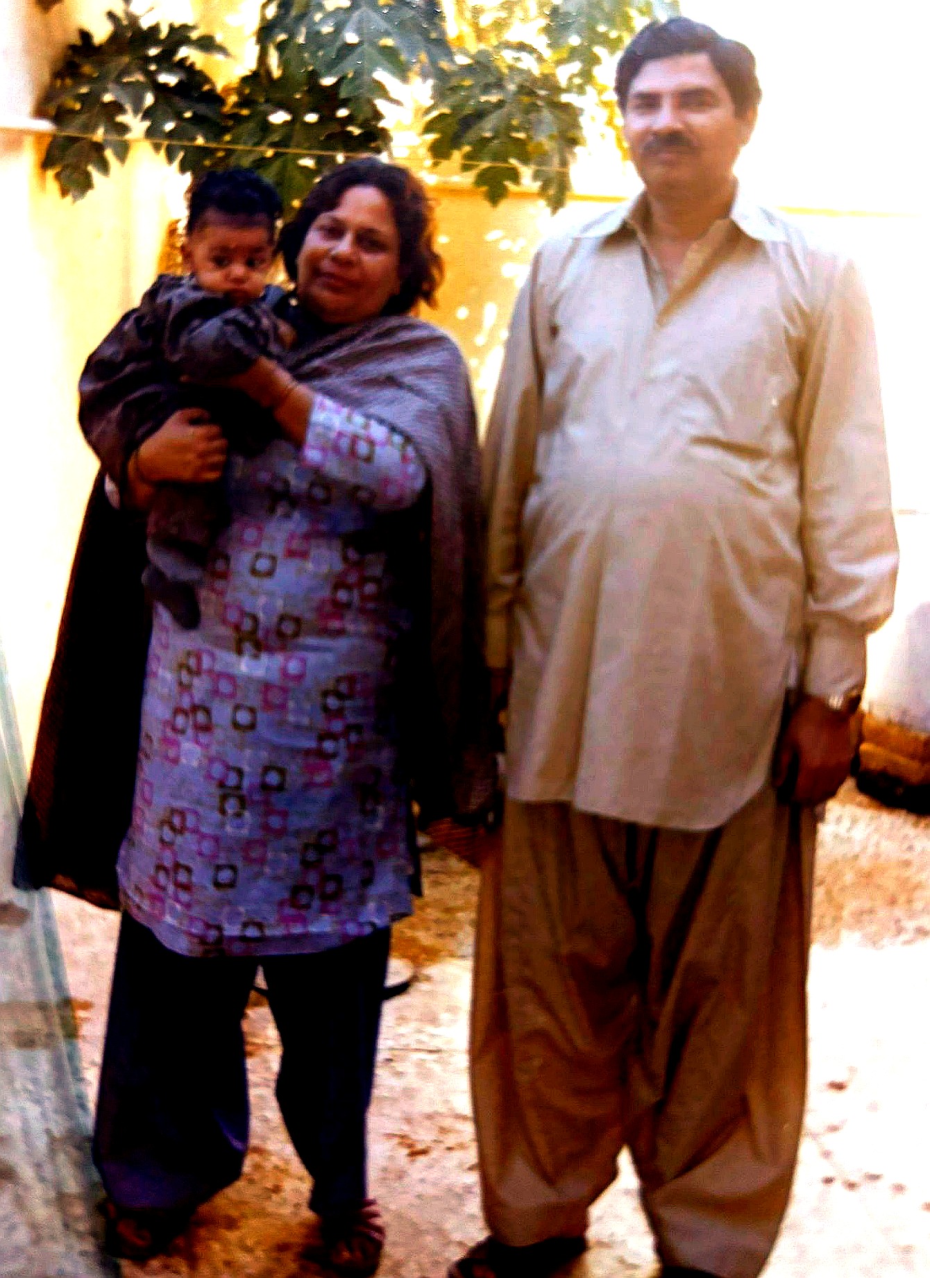 Aslam Hayat with his wife Suriya Hayat and a young child outdoors